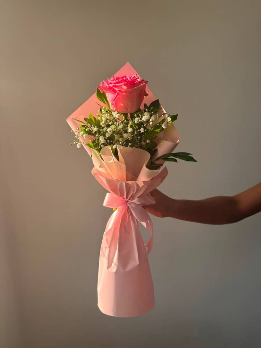 Soliflor: una rosa rosada con paniculata envuelta en papel rosa