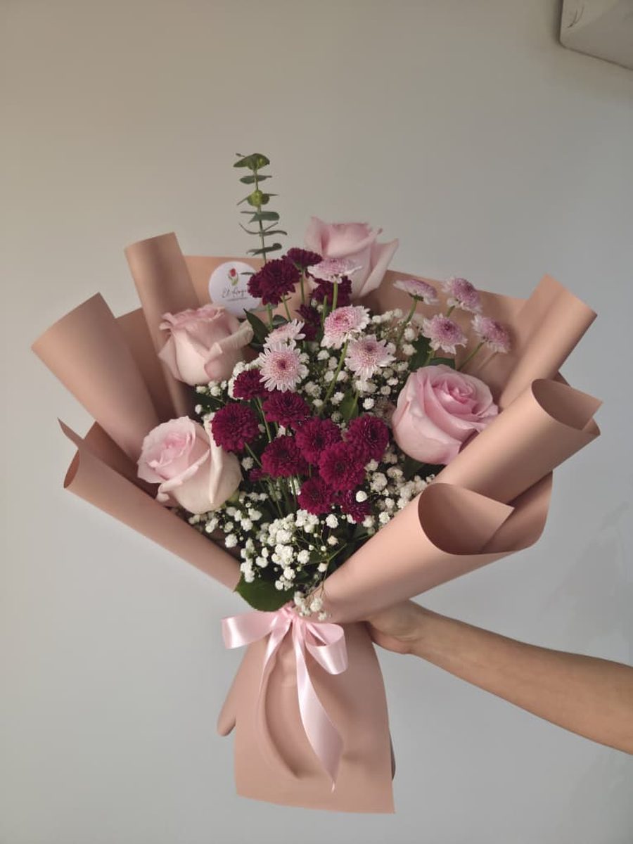 Ramo de rosas rosadas y crisantemos vino con paniculata en papel rosa