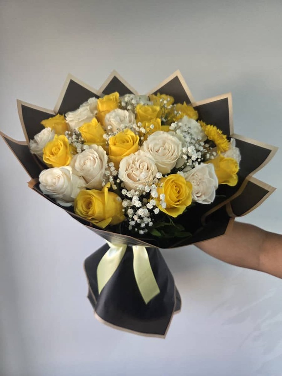 Ramo de rosas amarillas y blancas con paniculata en papel negro con borde dorado y lazo verde salvia