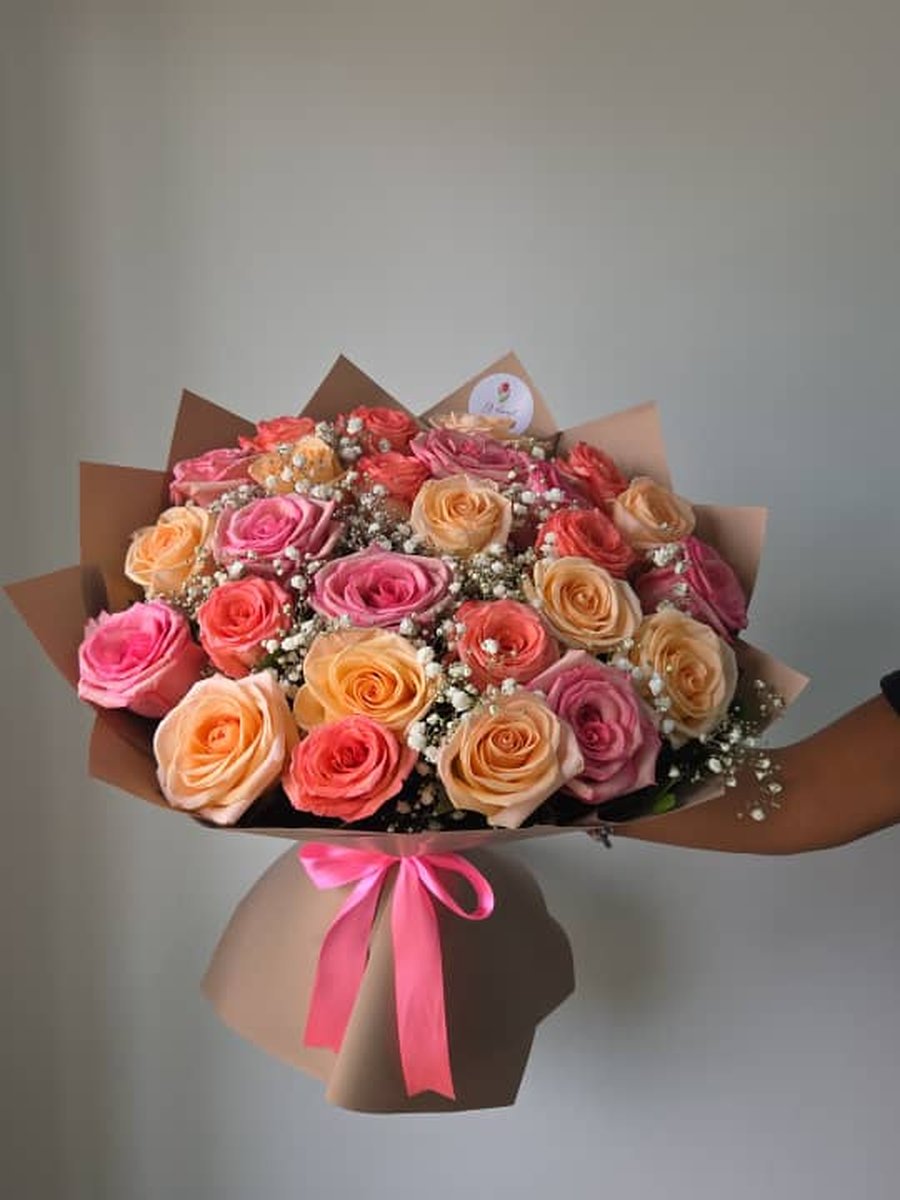 Ramo grande de rosas coral, durazno y rosadas con paniculata en papel taupe con lazo rosa
