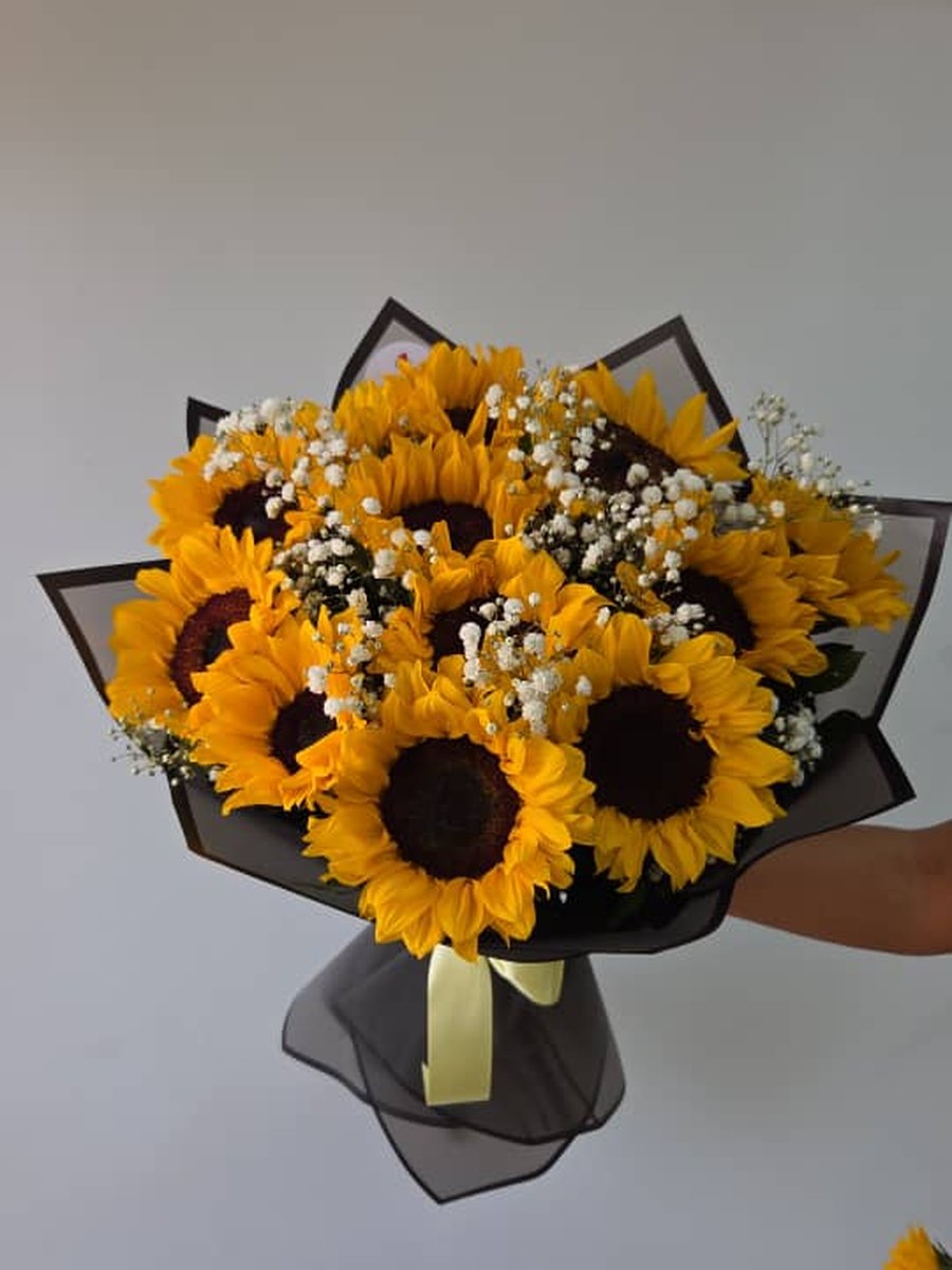 Ramo de girasoles con paniculata en papel negro con lazo amarillo
