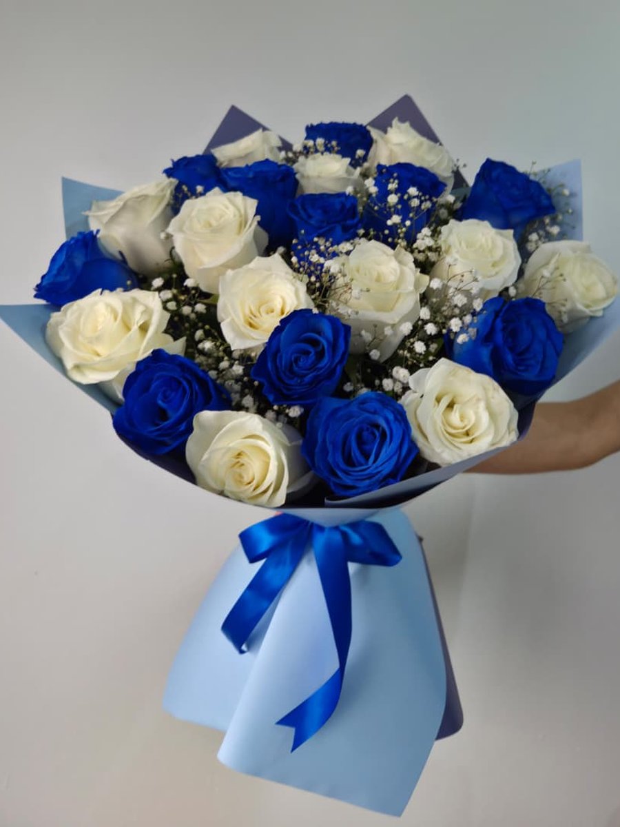 Ramo de rosas azules y blancas con paniculata en papel celeste con lazo azul