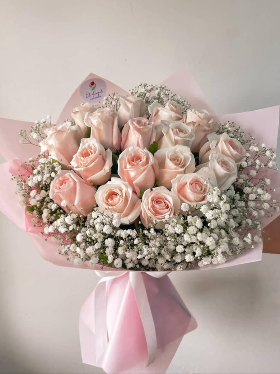 Ramo de rosas rosa pálido con abundante paniculata en papel rosa con lazo rosa