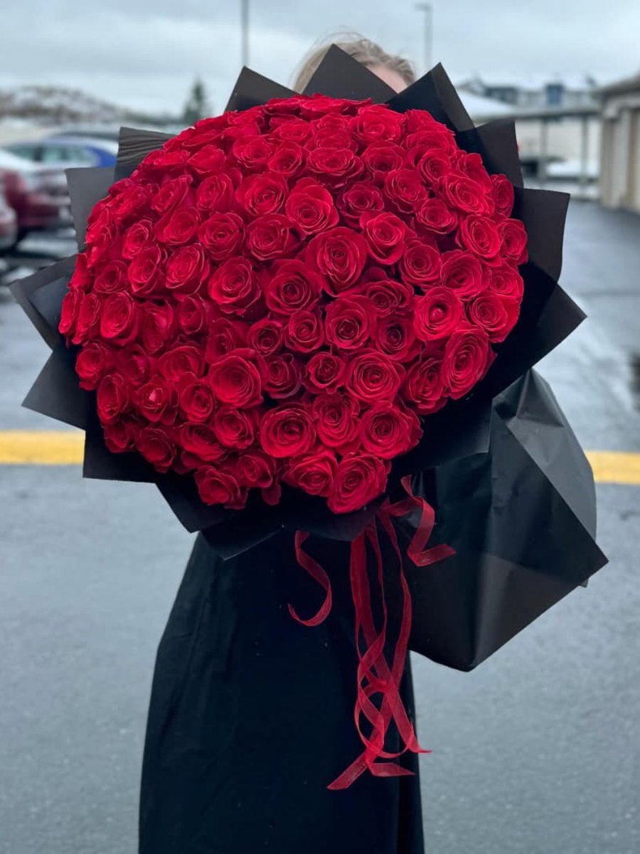 Ramo de cien rosas rojas en papel negro con lazo rojo