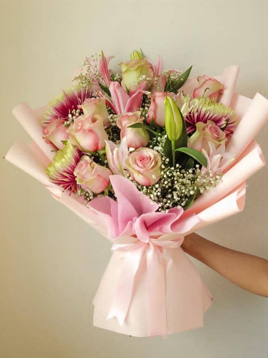 Ramo de rosas rosadas, lirios rosados y crisantemos con paniculata en papel rosa